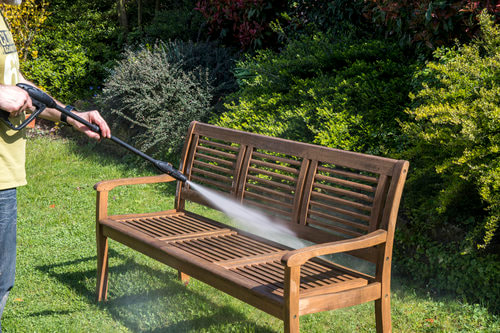 A wooden bench being cleaned and pressure washed.