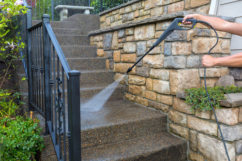 Residential exterior stair entrance being pressure washer cleaned.