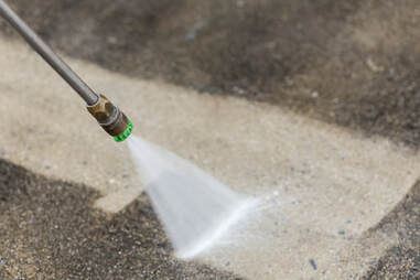 A pressure washer being used to spray the floor.